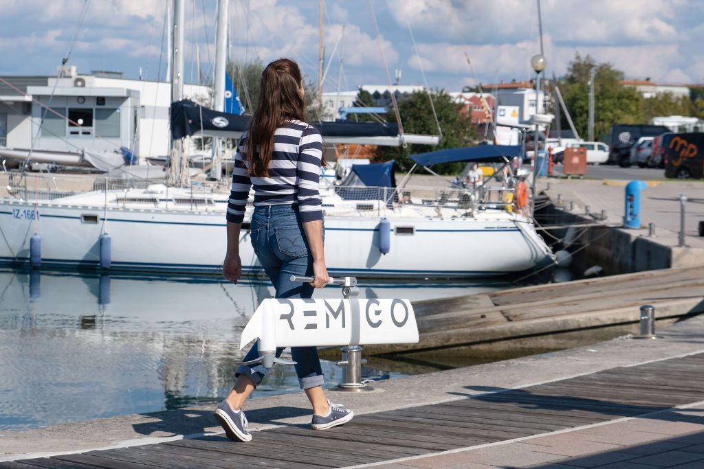 woman carrying an electric outboard in the marina