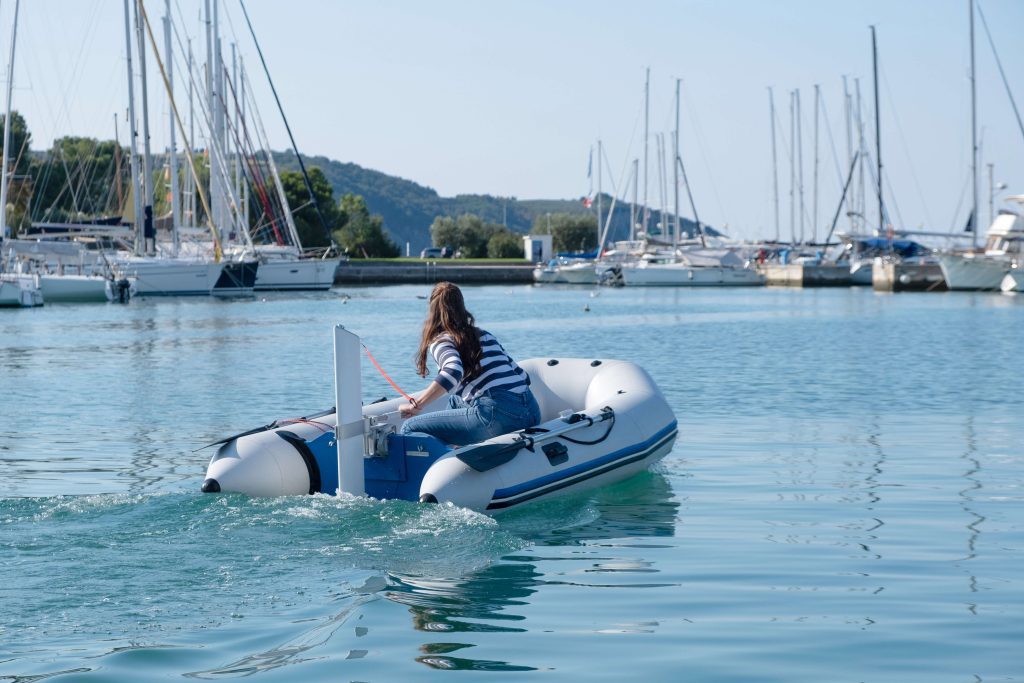 woman driving an electric outboard in the marina